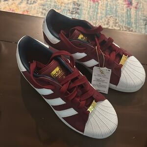 Brand new, never worn pair of Adidas women’s sneakers. Burgundy and white.